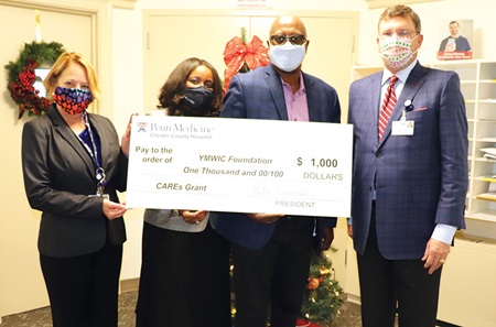 Jackie Felicetti, Rhonda West-Haynes, Richard Roberts, III, and Michael Duncan pose with the $1,000 Penn Medicine CAREs grant award, donated to Young Men and Women in Charge